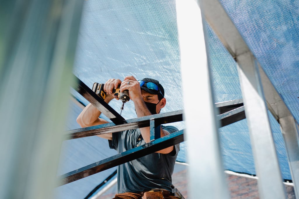 YWAM Homes of Hope volunteer screws in a truss on a build site in Mazatlan with YWAM in Mexico